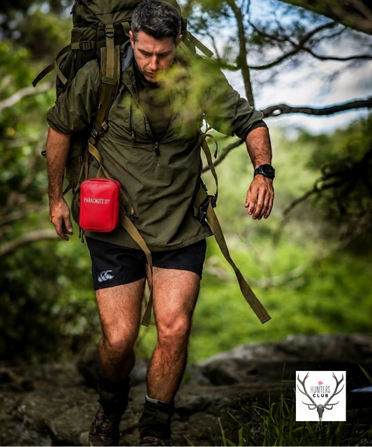 Man hiking with a red first aid kit bag in a forest,